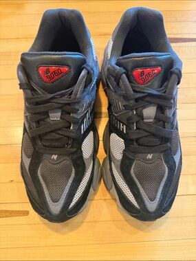 New Balance 9060 Grey and Black Athletic Sneakers with Red Logo Accents